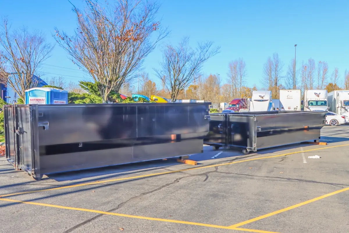 Professional dumpster rental service with roll-off container on residential driveway in Barton